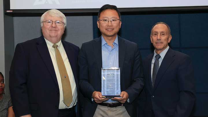 Dr. Yu Lei, center, receives the Outstanding Faculty Award for the College of Engineering from Dr. Keith Hollingsworth, interim dean of the college, left, and Dr. David Puleo.