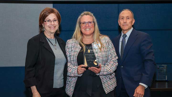 Tammy Shults, center, receives the Outstanding Faculty Award for the College of Nursing from Dr. Karen Frith, dean of the college, left, and Dr. David Puleo.