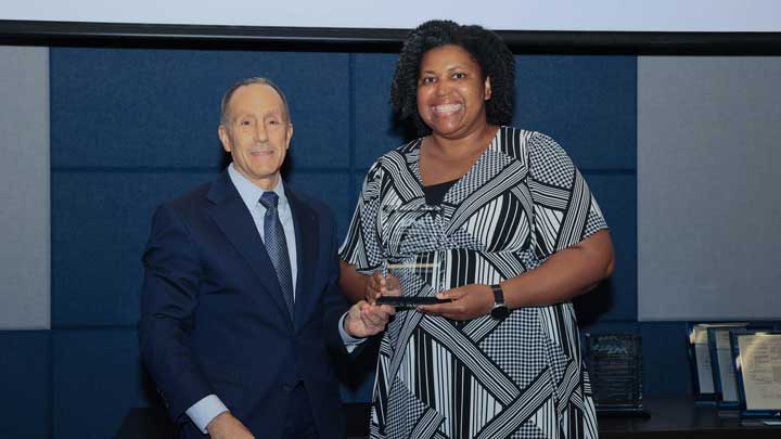Dr. Sharifa Love-Rutledge, right, receives the University Distinguished Teaching Award from Dr. David Puleo.