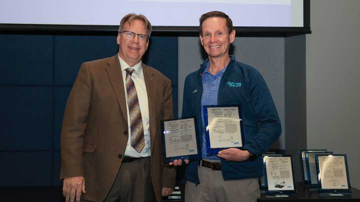 Dr. Robert Lindquist, left, presents patent award plaques to Dr. Tommy Morris.