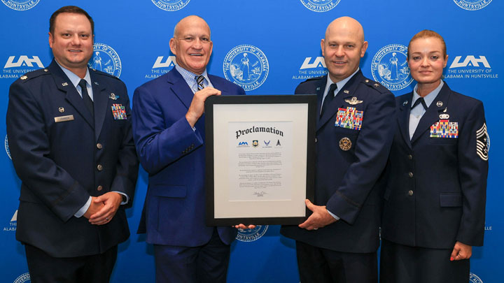Dr. Charles L. Karr, center left, president of The University of Alabama in Huntsville (UAH), presents a proclamation welcoming UAH’s new Air Force Reserve Officers’ Training Corps (AFROTC) operating location to U.S. Air Force Brig. Gen. Joseph Sheffield, center right, commander of the Jeanne M. Holm Center for Officer Accessions and Citizen Development at Maxwell Air Force Base, on Aug. 29, 2024. Also pictured are Lt. Col. Joseph Johnson, left, AFROTC Detachment 012 commander, and Chief Master Sgt. Jennifer McKeen.