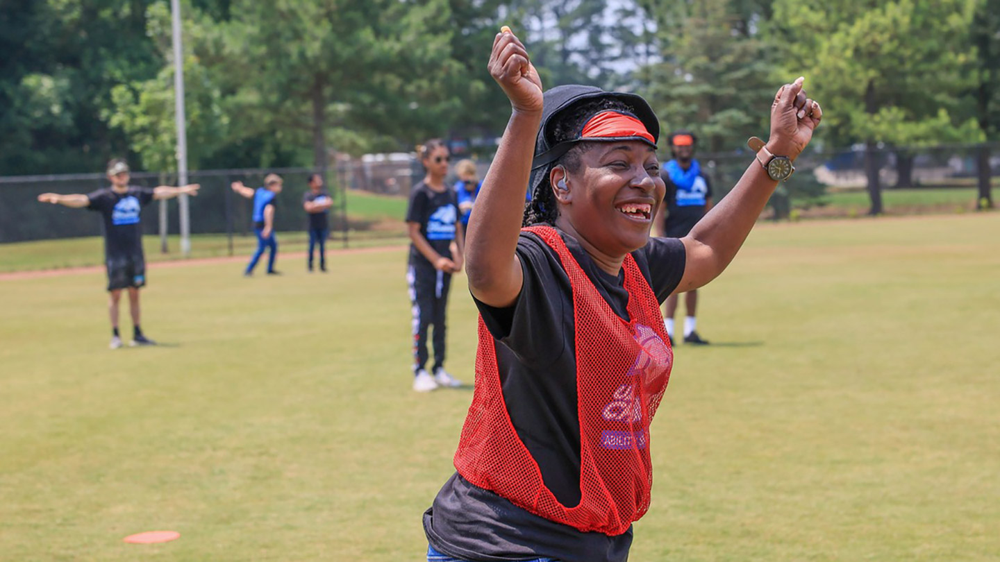 a vision impaired student cheers during a game of beep baseball