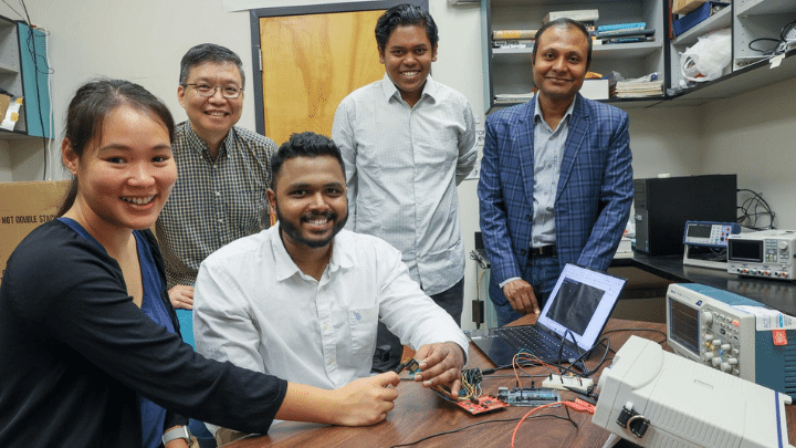 Dr. Ray with students posing in the Ray Research Group Lab