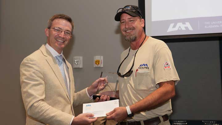 Brad Cooper, left, interim chief financial officer, presents the Facilities Excellence Award to Allen Butler