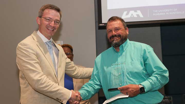 Brad Cooper, left, interim chief financial officer, presents the Staff Leadership Award to Dr. Michael Turner. 