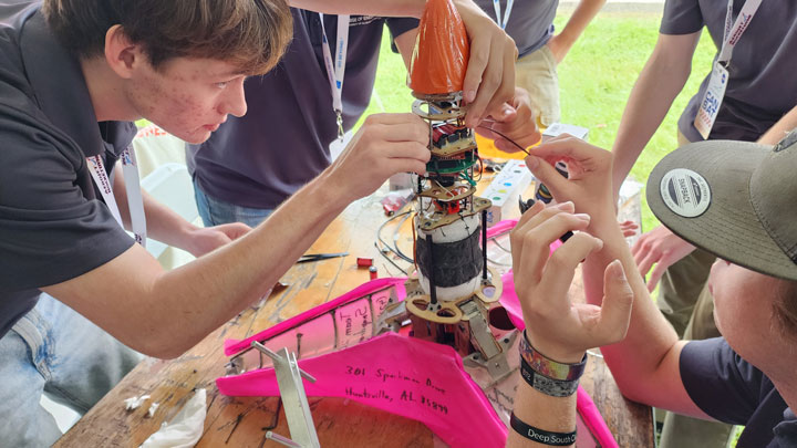 Team Snapdragon preparing their CanSat for flight at the launch site.