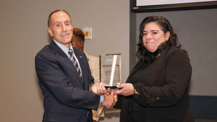 Dr. David Puleo, left, provost and executive vice president for academic affairs, presents the Research and Creative Activity Undergraduate Mentor Award to Dr. Samantha Moe.
