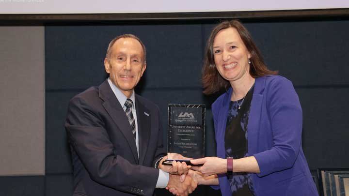 Dr. David Puleo, left, provost and executive vice president for academic affairs, presents the University Distinguished Teaching Award to Dr. Sarah Roller Dyess.