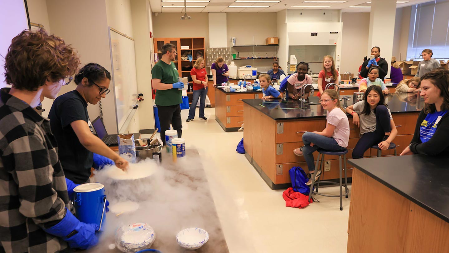 Volunteers show third- and fourth-graders how to make ice cream using liquid nitrogen 