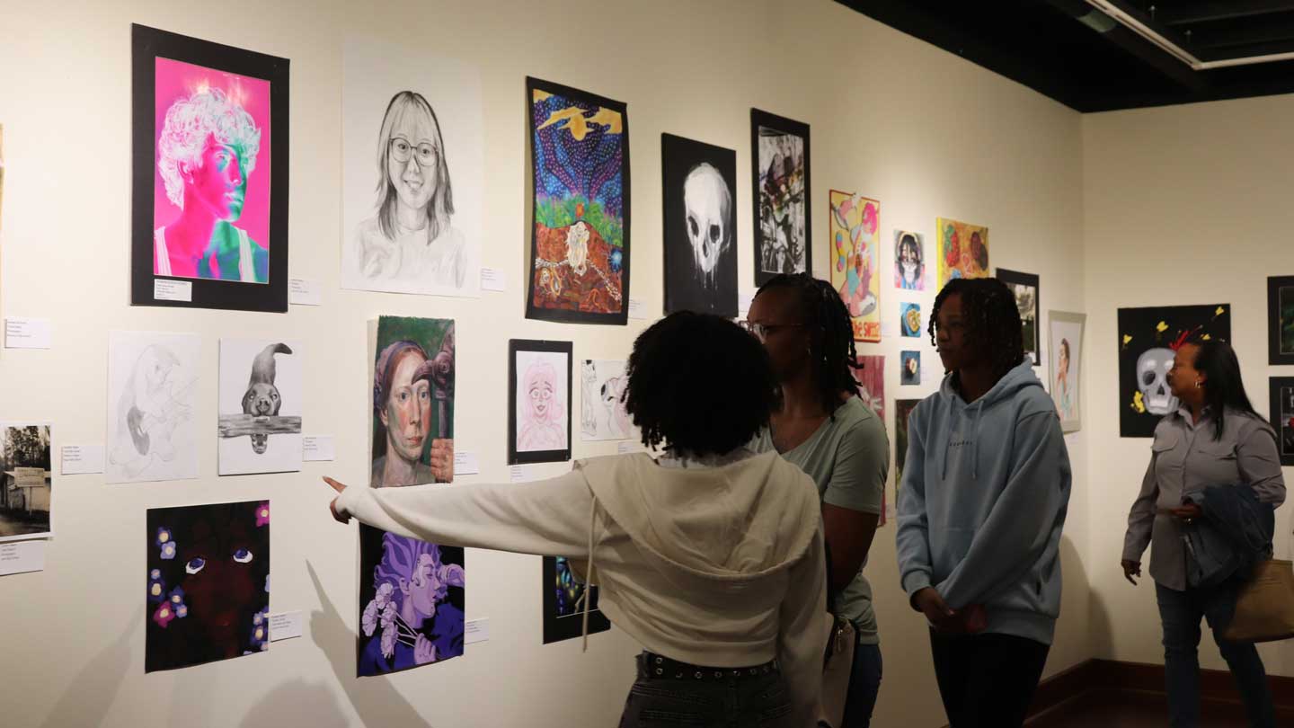 Attendees at the 2024 event view works of art in the Wilson Hall Gallery.