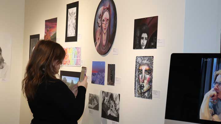 A student explores entries in the 2024 Art Expo.