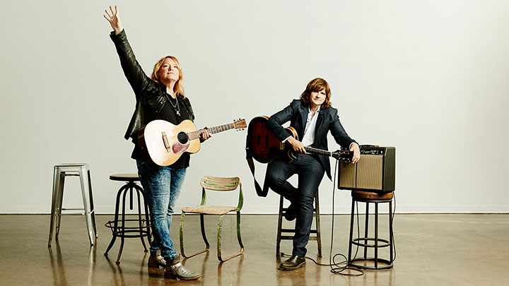 Indigo Girls standing on a stage holding guitars ?>