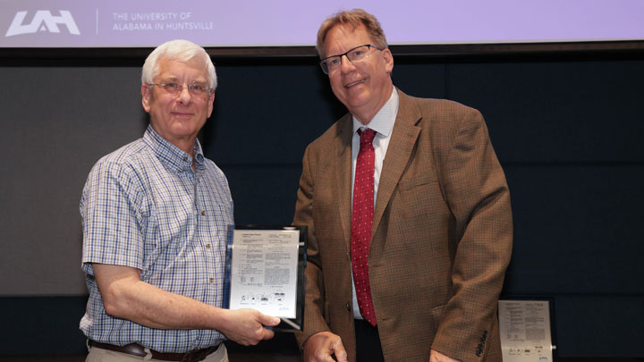 Robert Lindquist, right, congratulates Jeffrey Weimer for “Systems and Methods for Forming Uniform Monolayers of Nanoparticles,” developed with Jimmie Mitchell.