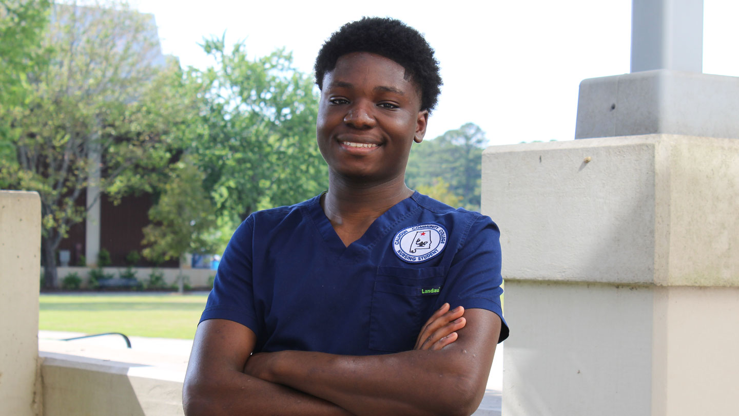 2024 spring nursing graduate Kehinde Oyediran stands outside the College of Nursing Building on the campus of The University of Alabama in Huntsville.