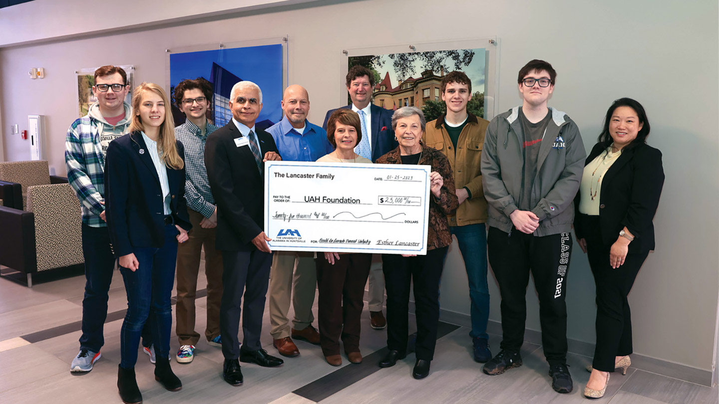a group of people stand in front of a large check