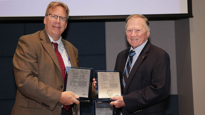 Robert Lindquist, left, congratulates James Blackmon for two patents, Apparatus and Method for Determination of Liquid Mass and Systems and Methods for Detecting Objects.
