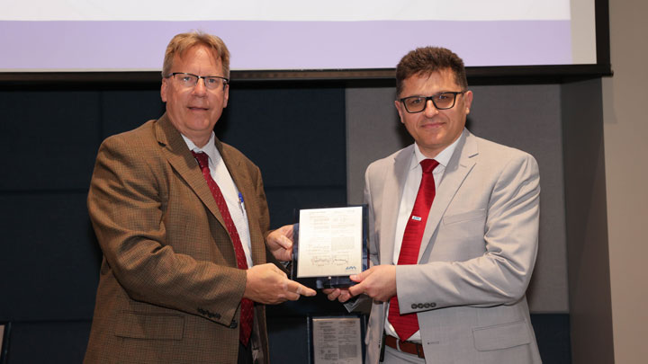 Robert Lindquist, left, congratulates Aleksandar Milenkovic for Flash-DNA: Identifying NAND Flash Memory Origins Using Intrinsic Array Properties.
