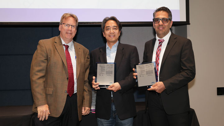 Robert Lindquist, left, congratulates Kyung-Ho Roh, center, and Armin Ahmadi for Identification and Evaluation of Novel Peptide Ligands Specific to Human CD3.