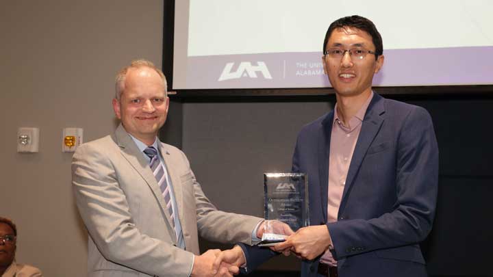 Dr. Rainer Steinwandt, left, dean, College of Science, presents the Outstanding Faculty Award to Dr. Xiaomin Chen.