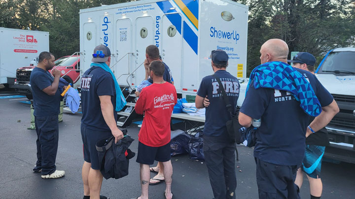Emergency workers in Asheville, N.C., wait to take a shower in a trailer provided by Shower Up Huntsville.