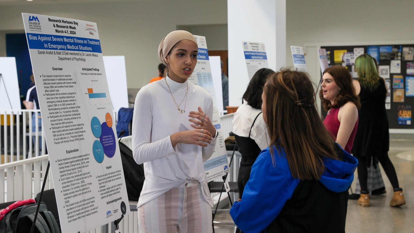 Student from The University of Alabama in Huntsville standing in front of a group of people