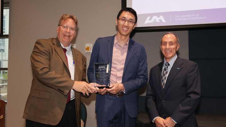 Dr. Robert Lindquist, left, vice president for research and economic development, and Dr. David Puleo, right, provost and executive vice president for academic affairs, present the University Distinguished Research, Creative Achievement and Scholarly Performance Award to Dr. Xiaomin Chen.
