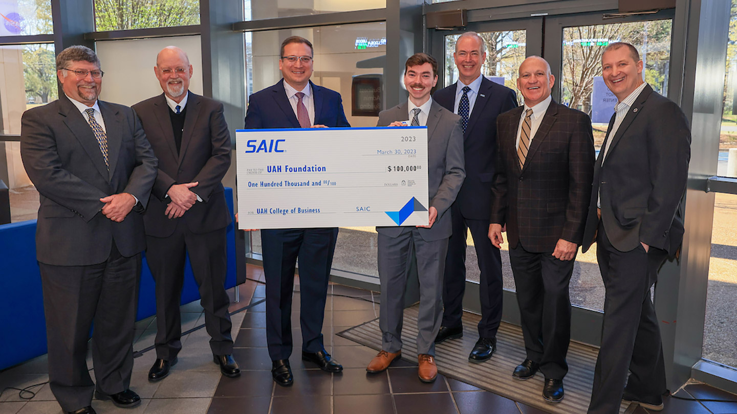 group of men in suits accepting a check