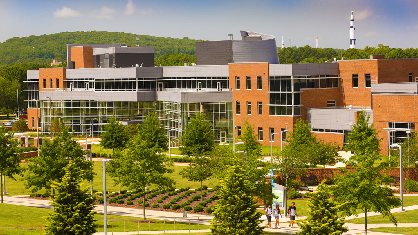 the campus of UAH with a saturn five rocket and mountain in the background