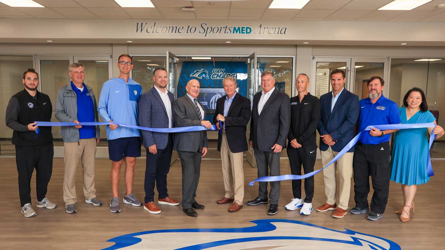 Gathering for the ribbon-cutting ceremony are, from left, Tyler Daniel, UAH assistant athletic director for internal operations; Jon Moseley, head coach, UAH volleyball; Mick Hedgepeth, head coach, UAH men’s basketball; Dr. Cade Smith, director, UAH Athletics; Dr. Charles Karr, UAH president; Dr. Eric Janssen, SportsMED orthopedic surgeon; Blake Bentley, SportsMED CEO; Allen Sharpe, head coach, UAH women’s basketball; Penn Garvich, UAH deputy athletic director for external operations; David Cain, head coach, UAH men's and women's cross country and track and field programs; Dr. Helen Lien, senior development officer, UAH Athletics.