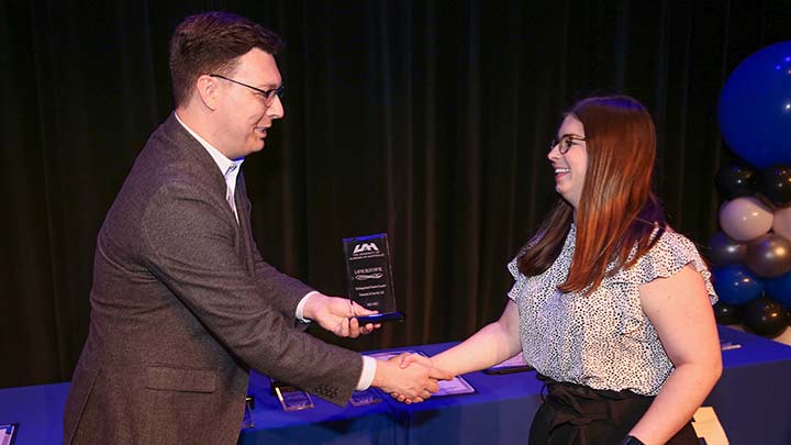 Layne Bleyswyk accepts award from William Hargrove