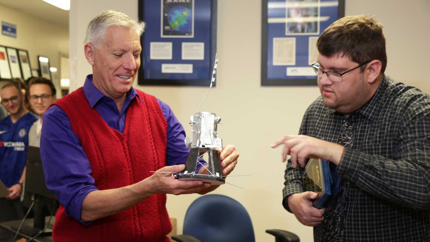 Dr. Gary Zank, director of the UAH Center for Space Plasma and Aeronomic Research (CSPAR), holding a model of the Parker Solar Probe and SWEAP instrument suite created by Blake Parker.