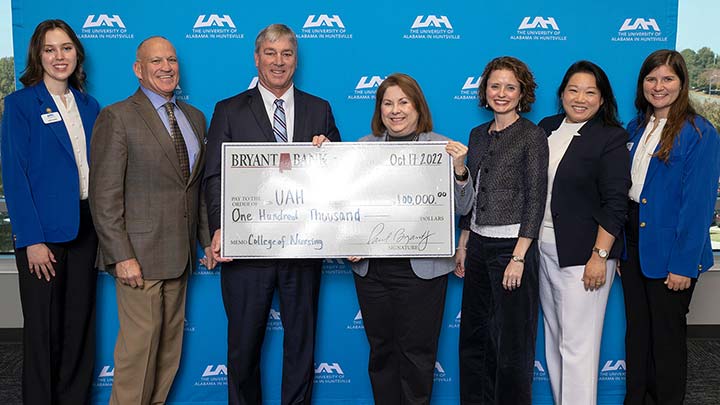 a group of people stand in front of a large check.