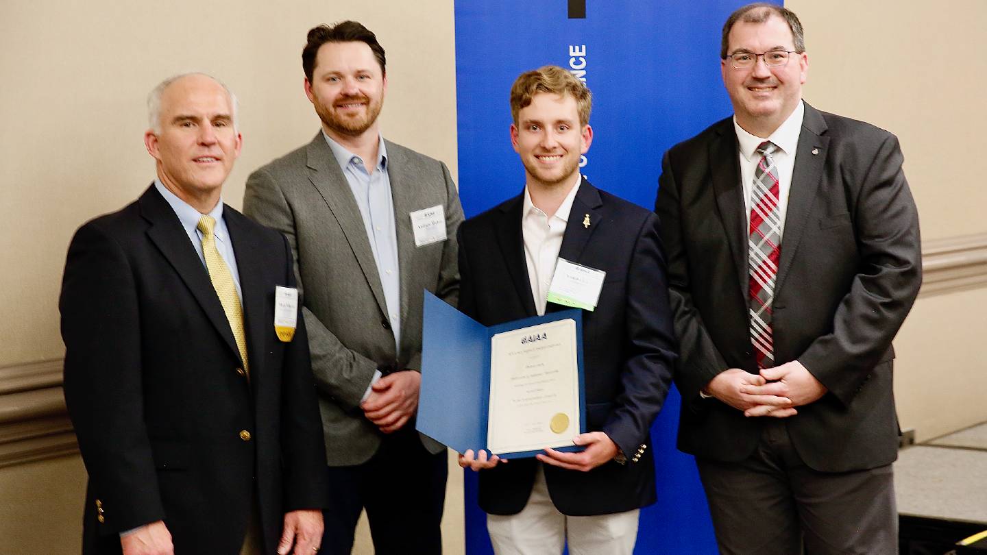 group posing with aiaa award