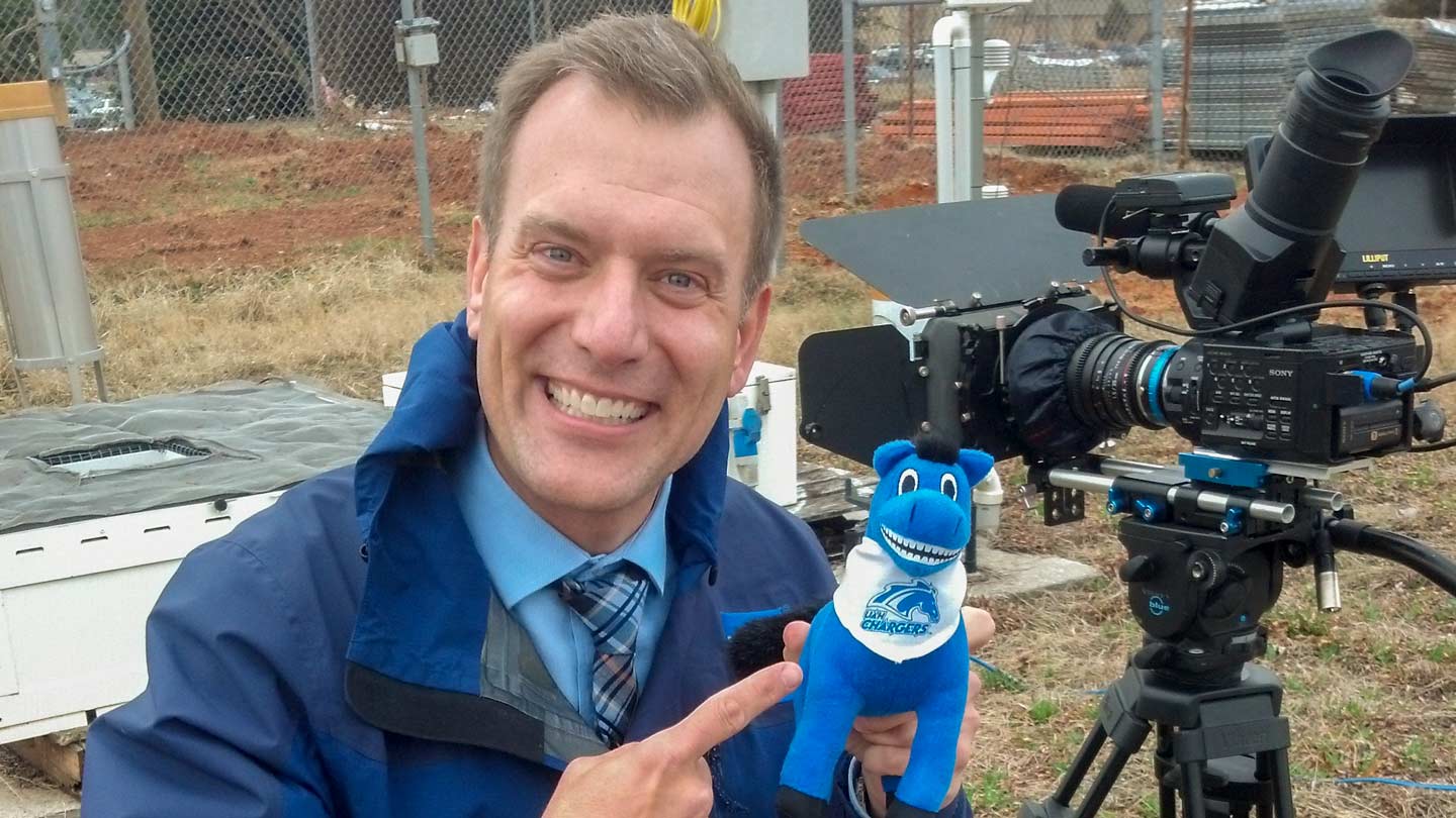 Mike Bettes takes a break with Charger Blue during 2014 Weather Channel coverage on campus.