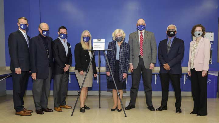 eight people standing with named Communications & Signal Processing Laboratory plaque.