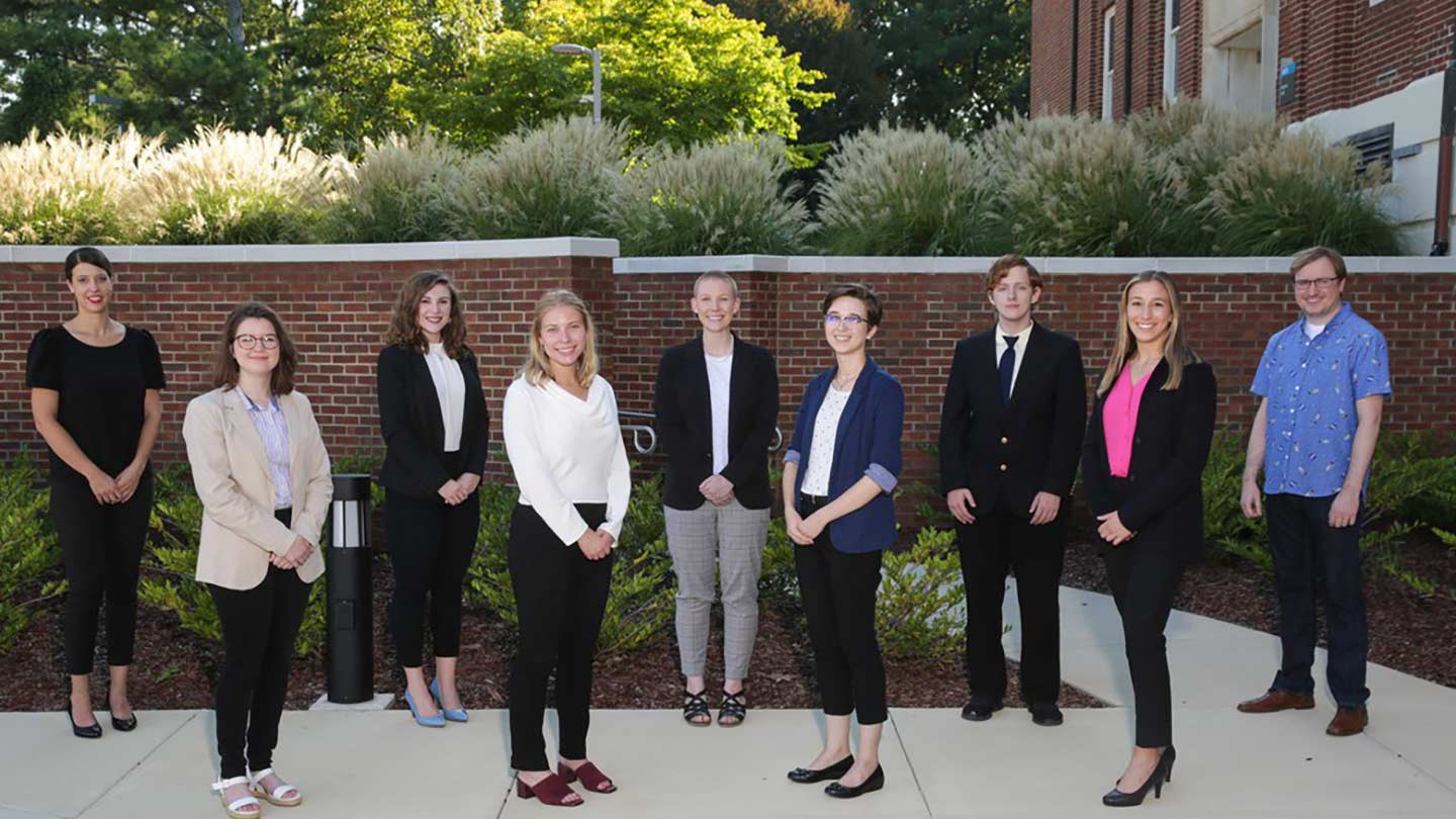 INCLUDE team posing outside at UAH in front of a brick wall.