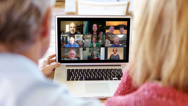 Man and Woman on a laptop displaying other users of an online meeting. ?>