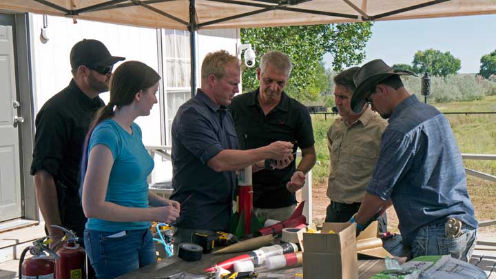 Six people prepare an experimental payload prior to launch.