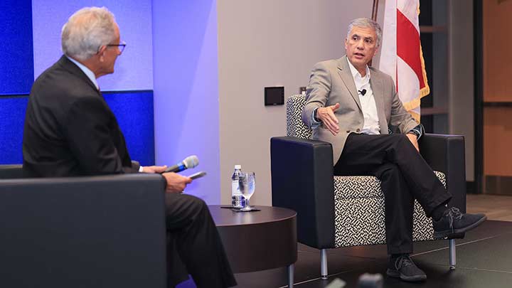 Steve Johnson and Paul Nakasone setting in chairs during an interview.