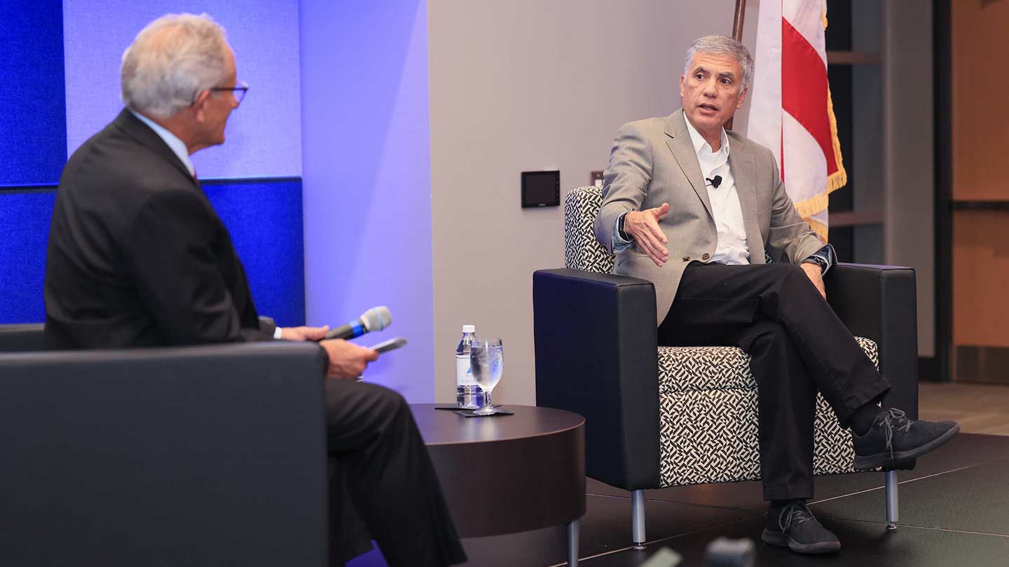 Steve Johnson and Paul Nakasone setting in chairs during an interview.