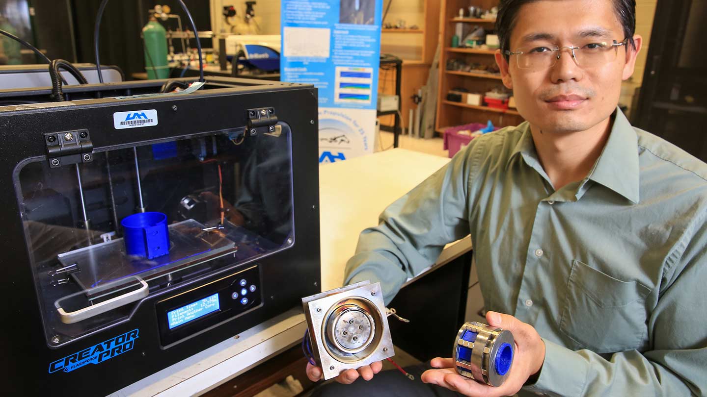 Dr. Gabe Xu holding tech in a lab setting.