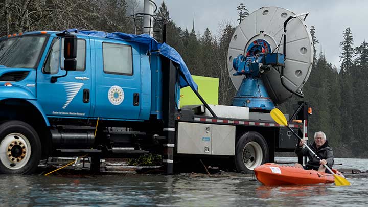 DOW truck driving through a flooded area while a person is also in a canoe.