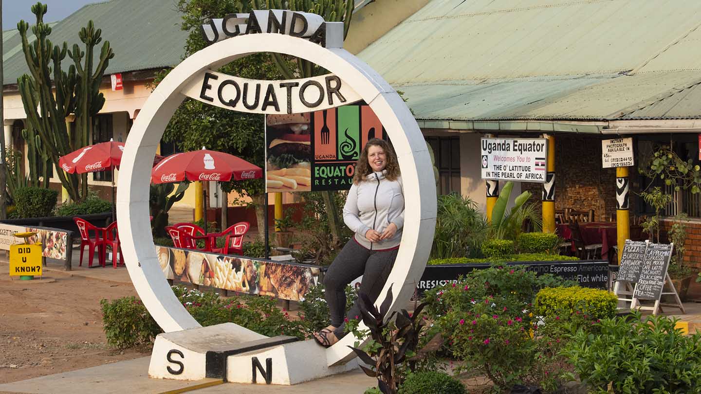 Emily Gothro in Uganda under the equator sculpture