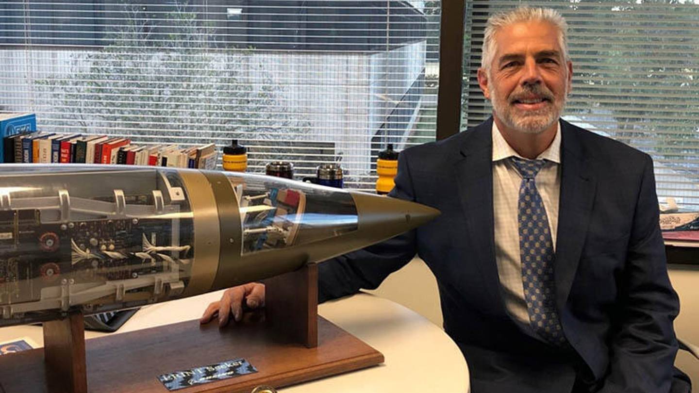 Robert Green posing next to a Boeing model in an office