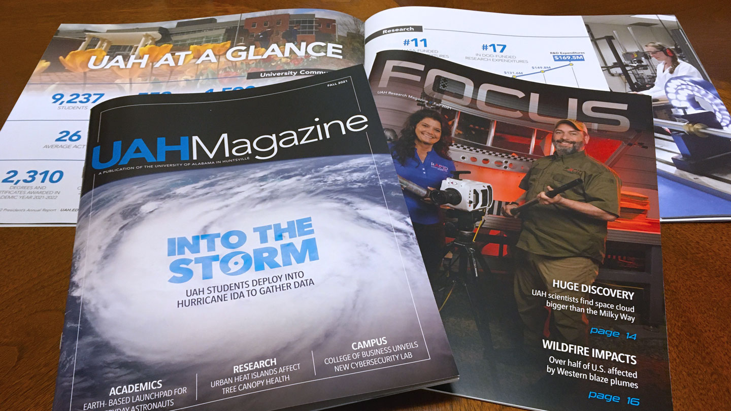 A selection of U A H published magazines lie on a wooden table.