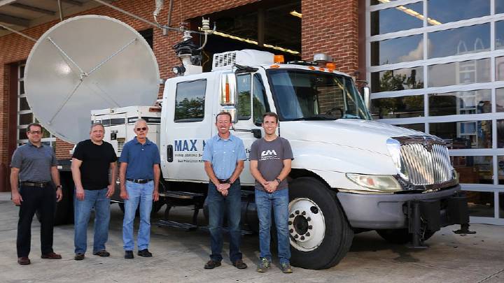 Photo of UAH faculty standing near weather radar.