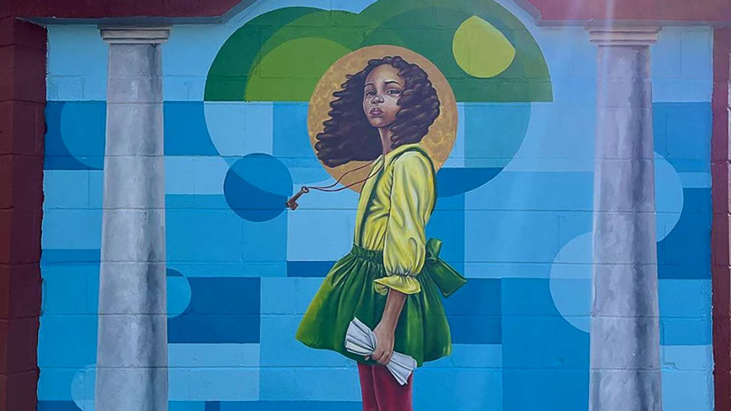 mural of a girl against a blue sky.