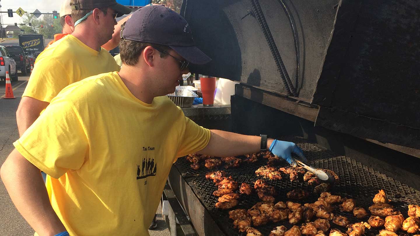 Bobby Marsh, outside, grilling food. ?>