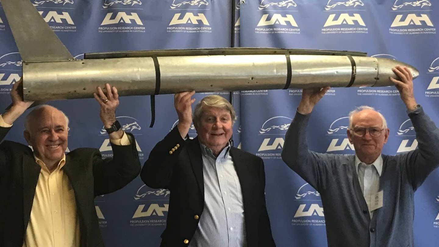 Bill Snoddy, Dr. Robert Naumann, and Harry Reid pose with a replica of Explorer 1