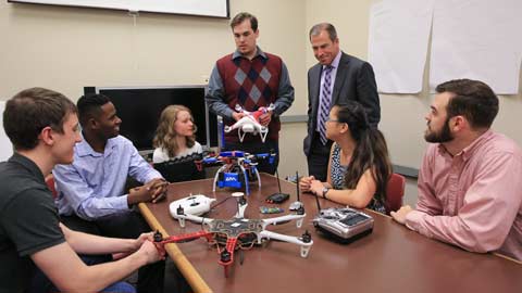 A UAH senior design class explains their strategy for drone defense to Bob McCaleb, Northrop Grumman corporate lead executive, at Olin B. King Technology Hall on campus. From left are Daniel Bernues, Tevon Walker, Alyse Adams, William Klingbeil, McCaleb, Faith Buckley and Zack Horvath.  ?>